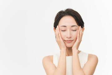 スキンケアプロセス。スキンケアの仕上げにハンドプレスをする女性。