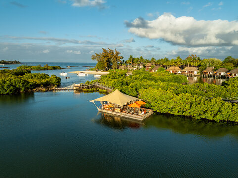Aerial view of a serene floating restaurant amidst lush mangrove forests, contrasting with the calm, reflective waters, Prince Maurice, Flacq District, Mauritius.