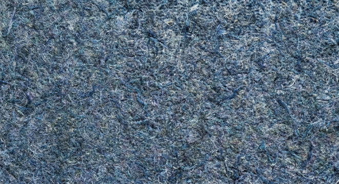 Macro top view of sustainable recycled denim insulation board texture. Indigo and blue-grey organic fibers with a felt-like tactile surface. Eco-friendly textile waste material with copy space