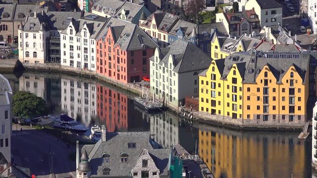 Colorful buildings by the water in Alesund showcase stunning architecture and reflection at sunny day