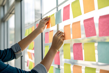 macro shot of hands paste colorful sticky notes on mirror