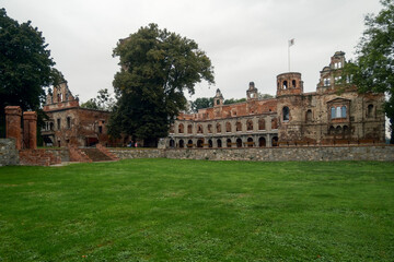 Fototapeta premium Lush Green Area. Vast Grassy Field Leading To Historic Buildings With Scenic And Cultural Significance