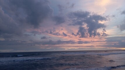 Obraz premium Colorful twilight sky above dynamic sea waves at coastline, suitable for environmental awareness projects, background footage, branding, atmospheric scenes.
