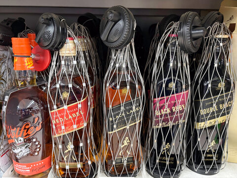 St Neots, UK - Friday 19th December 2025: Johnnie Walker Whisky with anti theft tags and security nets to deter shoplifters 