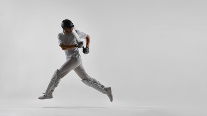 Cricket player sprinting while holding bat isolated on white background. Concept of cricket academy campaigns, youth sports promotion, fitness training advertising and active lifestyle marketing. © master1305