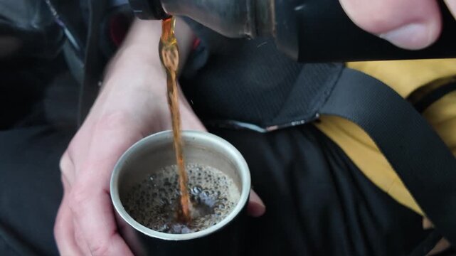 Pouring Hot Beverage Into Mug. Closeup Of Hands Pouring Steaming Coffee Into Travel Mug Inside Vehicle. Detailed Shot Of Pouring Hot Coffee Into Foamfilled Travel Mug On Dashboard While Traveling