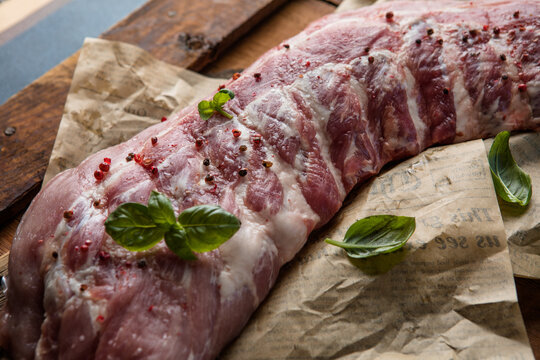 Fresh baby back pork ribs on a cutting board in a kitchen ready for grilling
