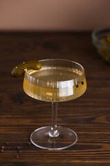 Cucumber pickle in a glass with a pickled cucumber on a fork. Hangover drink. Vertical orientation.