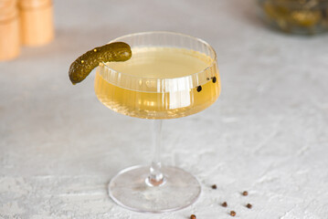 Cucumber pickle juice or brine in a glass with a pickled cucumber. Hangover drink.
