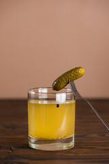 Cucumber juice or pickle drink with cucumbers on the wooden table. Pickled vegetables preserved, canned greens, marinated greens, pickled cucumber. Vertical orientation.