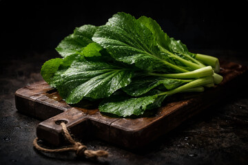 Fresh Green Mustard Leaves on Wooden Table with Dark Lighting