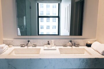 Modern marble bathroom with double sinks and large mirror reflecting urban window view