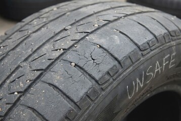Close up texture of old worn out car tire tread with no grip showing safety accident risk