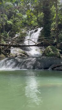 Stunning multi tiered Curug Bibijilan waterfall with emerald green water in Sukabumi, Indonesia.
