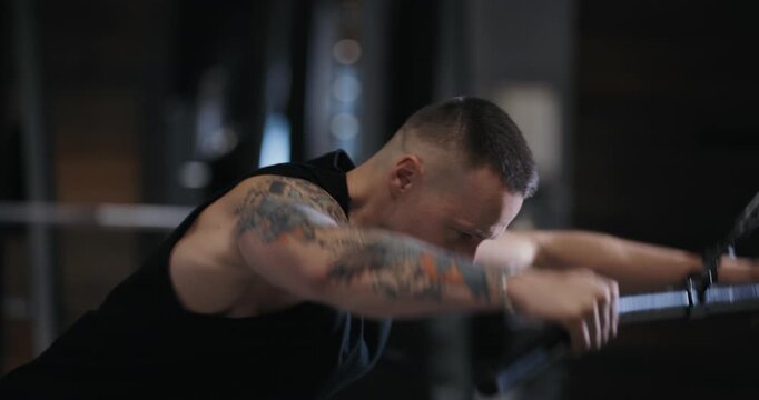 A man doing pullover exercise on training apparatus pumping his muscles in the gym