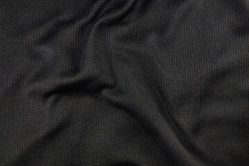 Close up of black ribbed textile fabric texture with natural folds