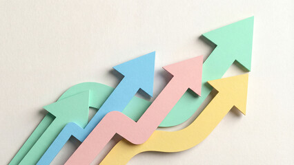 パステルカラーの紙が層になって重なり、ふんわりとした影を落としながら上昇する矢印を描いています。優しく右肩上がりに伸びる曲線は、無理のない成長や調和のとれた発展を象徴しています。教育関連やクリエイティブなプロジェクト、女性向けのビジネス資料に最適です。