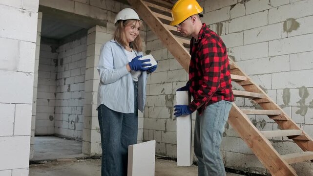 Team of skilled builders working in half-built residential house