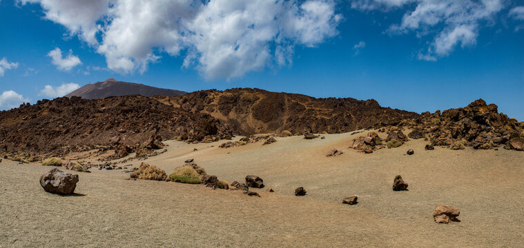 Tenerife, Canary Islands, Spain: red mountains, rock formations and rainbow sand dunes hiking in the Teide National Park with Mount Teide (Pico del Teide) on the background, spectacular landscape