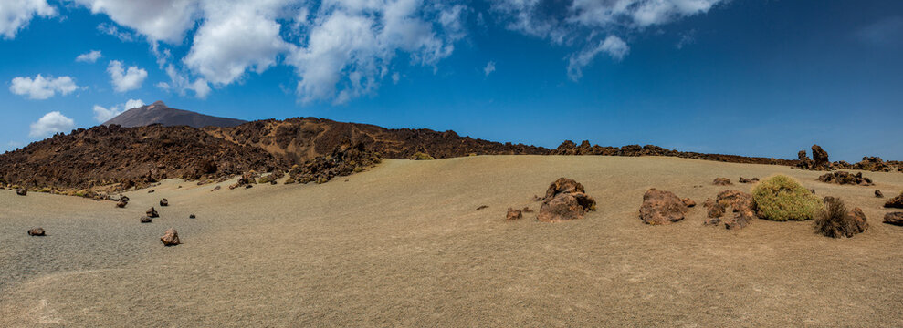 Tenerife, Canary Islands, Spain: red mountains, rock formations and rainbow sand dunes hiking in the Teide National Park with Mount Teide (Pico del Teide) on the background, spectacular landscape