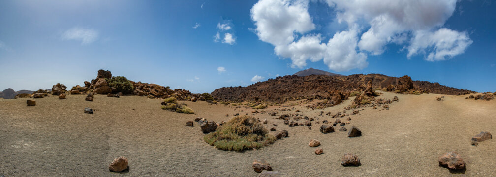 Tenerife, Canary Islands, Spain: red mountains, rock formations and rainbow sand dunes hiking in the Teide National Park with Mount Teide (Pico del Teide) on the background, spectacular landscape