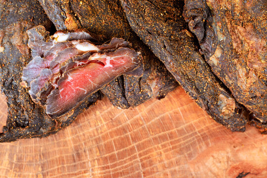 Beef jerky laid on wooden board with close up r details in natural lighting