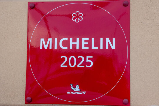 Rote Michelin-Plakette mit der Aufschrift &bdquo;Michelin 2025&ldquo; und einem Sternsymbol an einer Geb&auml;udefassade 