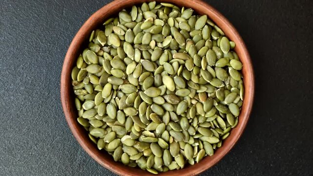 Shelled pumpkin seed kernels, salted, roasted, or raw, are a healthy ingredient. Pumpkin seeds as a food background for your design