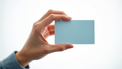 Obraz premium Person holds empty light blue card on white background. Blank space for text, data, or contact info. Clean template for business, marketing, or personal use.