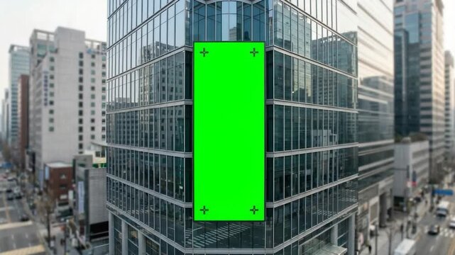 Modern glass office building facade with large vertical green billboard mockup urban downtown exterior advertising display screen for branding marketing and commercial promotion concept