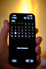 Handy Iphone in der Hand mit Kalender 