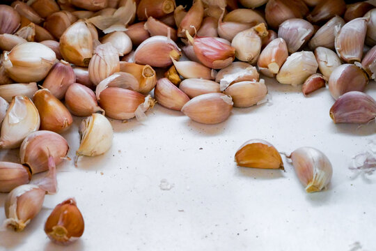 Small garlic cloves are stored in boxes, ready for repackaging and sale.