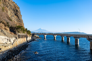 冬の快晴に映える大崩海岸の海上高架橋と駿河湾越しに望む富士山
