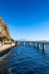 冬の快晴に映える大崩海岸の海上高架橋と駿河湾越しに望む富士山
