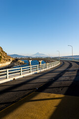 冬の快晴に映える大崩海岸の海上高架橋と駿河湾越しに望む富士山
