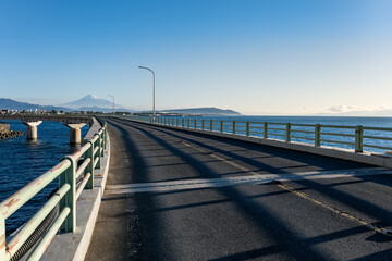 冬の快晴に映える大崩海岸の海上高架橋と駿河湾越しに望む富士山
