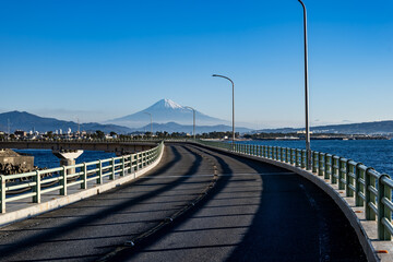富士山へと続く真っ直ぐな海沿いの道が描く旅の風景
