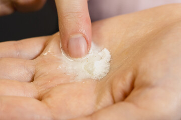 Fototapeta premium Woman mixing enzyme powder in hand for apply to face. Close up.