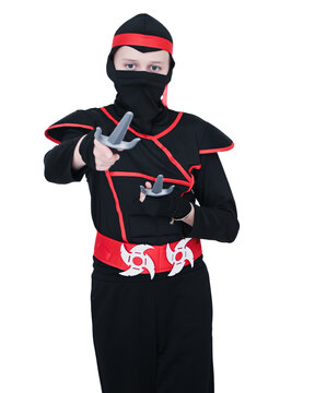Boy dressed as a ninja holding toy sai daggers on a white background