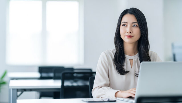 会社のオフィスでパソコンを使う女性：デスクワーク