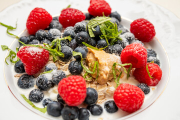 Obraz premium Closeup of healthy yogurt with berries nuts and mint