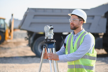 Engineer working with surveying equipment at construction site