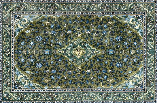 Close up of classic middle eastern Persian rug texture. Engraving and floral ornamental swirls pattern in random green and blue color. For moslem prayer mat and decorative rug. Arab middle east vibe.
