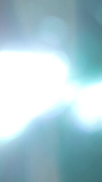 Flaring Vertical Flashing Light Bokeh Transition, Bright Abstract Light Flare Over Dark Background. great for overlay effect