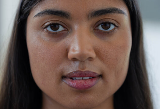 African American adult woman facing camera, filling frame indoors, showing brown eyes, parted lips