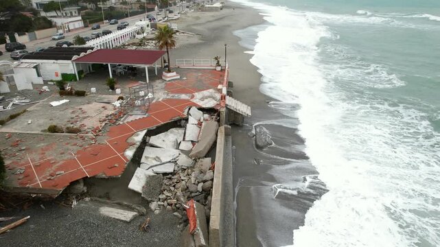 An aerial view of damaged coastal infrastructure and a beach after a severe storm. A panoramic drone shot of the coastline in Southern Italy, Locri, February 13, 2026.