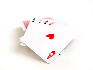 Obraz premium Four playing cards displaying the aces of hearts, clubs, spades, and diamonds are shown, fanned out on a white background.