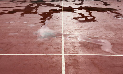 Naklejka premium Wet clay tennis court with puddles during the rain. Outdoor tennis season. Spring rain on courts. All practices and match are cancelled
