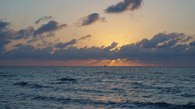 Sunset cloudy sky. Seascape at summer vacation. Skyscape with sea horizon. Horizon sunrise sea with ship. Sunrise seascape. Romantic summer vacation seascape. Sea sunset horizon. Golden hour