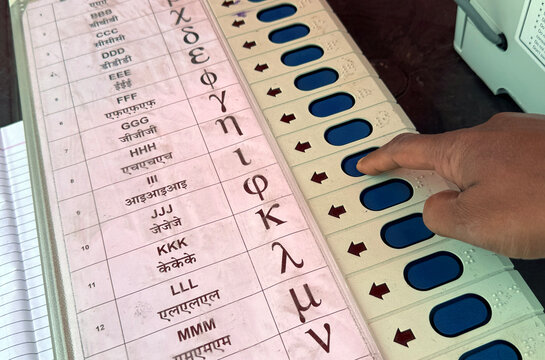 Person presses a button on an Electronic Voting Machine (EVM)